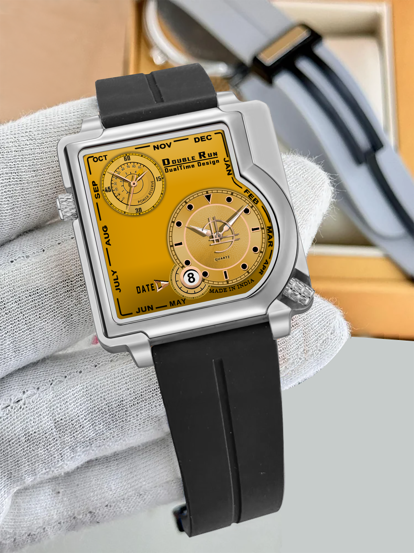 Luxury square dial golden watch with dual time feature on black strap displayed in a leather watch box.